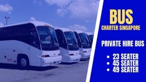 Row of white coaches beside a panel reading Bus Charter Singapore private hire bus, 23, 45 and 49 seater