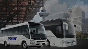 Charter bus loading passengers and luggage at a Singapore airport terminal kerb